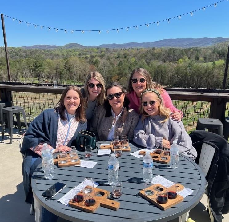 Friends enjoying wine tasting on a patio during a birthday celebration tour